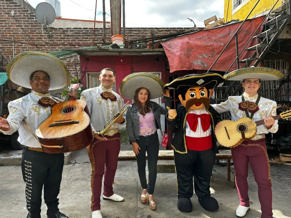 Mariachis y el muñeco Toribio González posando con una clienta