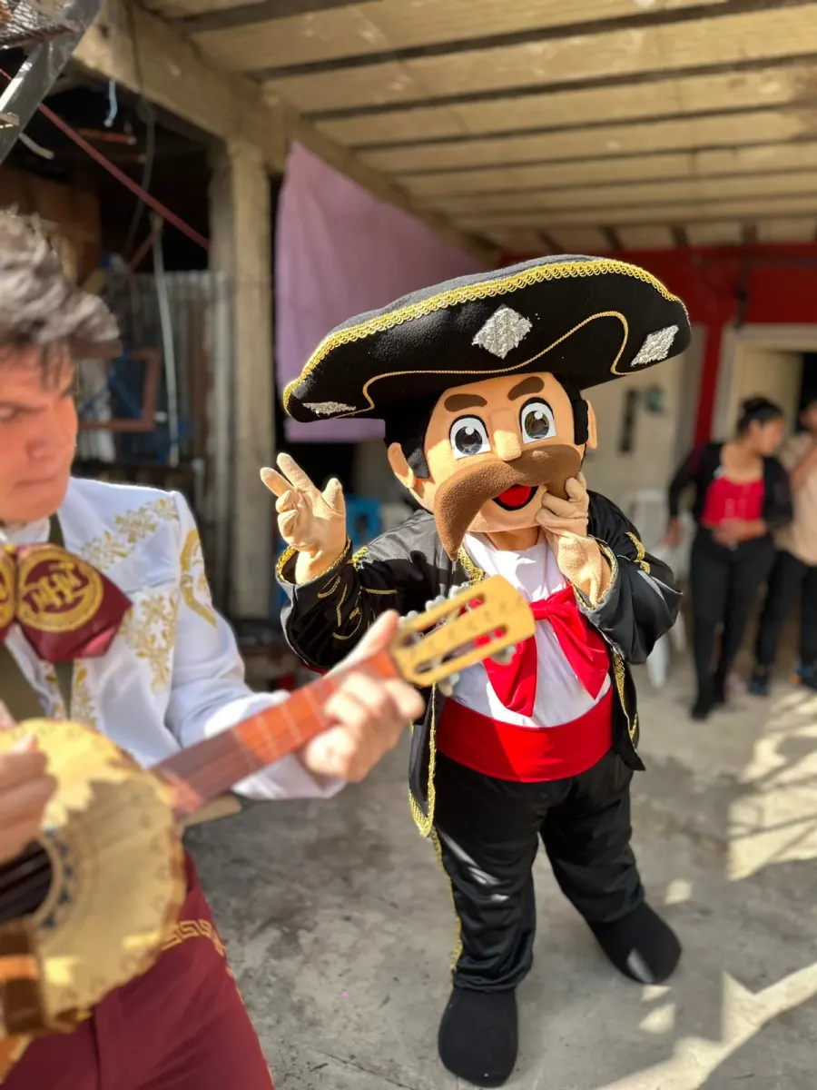 El muñeco Toribio González saludando junto a un guitarrista del mariachi